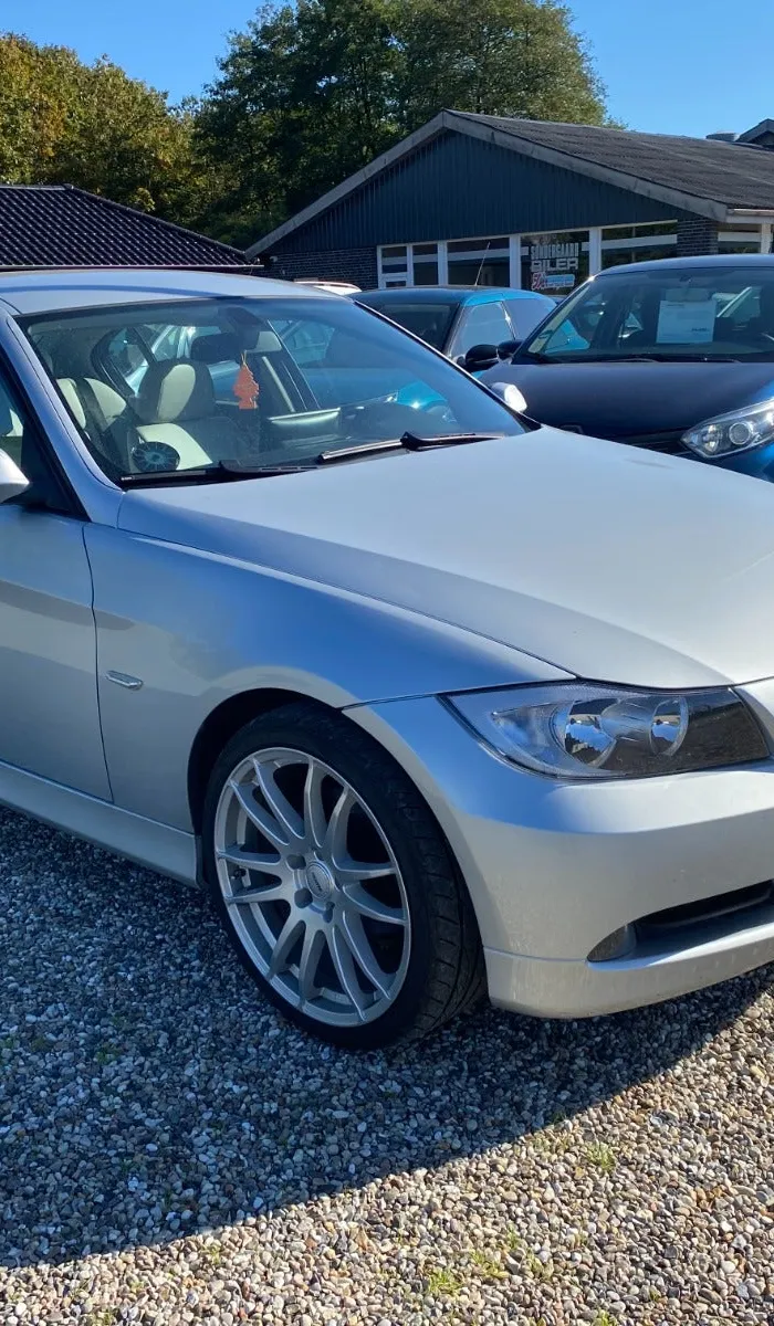 Sølvfarvet BMW 320i 2,0 benzin, set skråt forfra