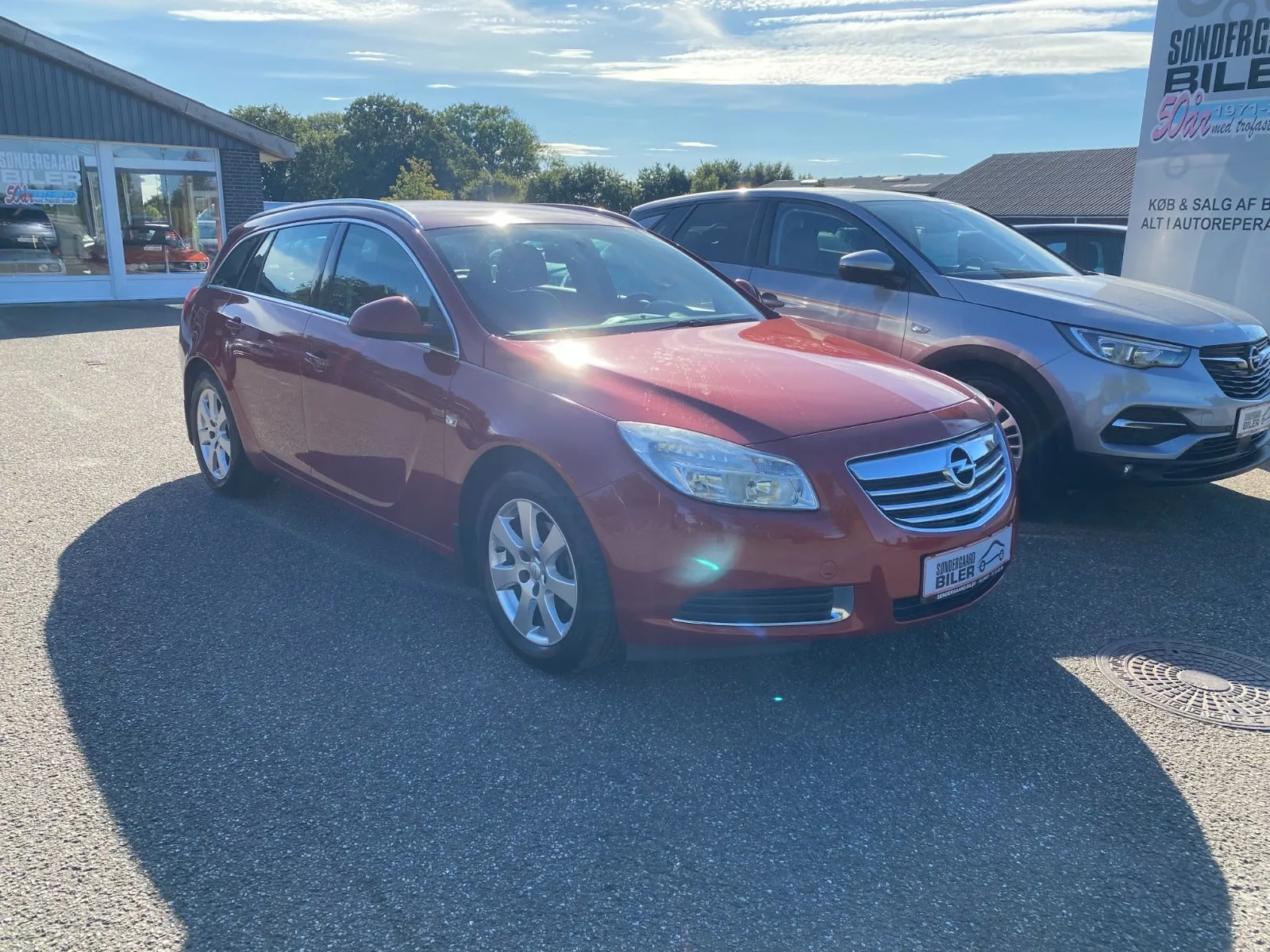 Rød Opel Insignia Edition Sports Tourer 1,8 benzin, set skråt forfra